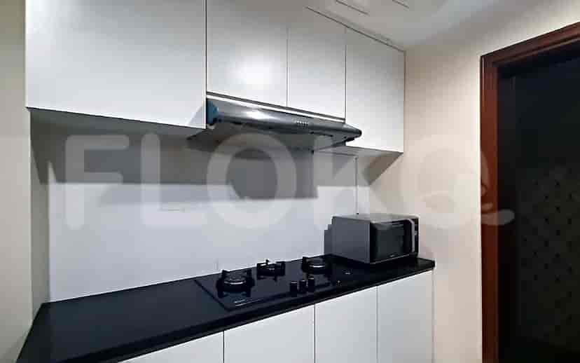 A kitchen with a gas stove, a microwave, and cabinets.