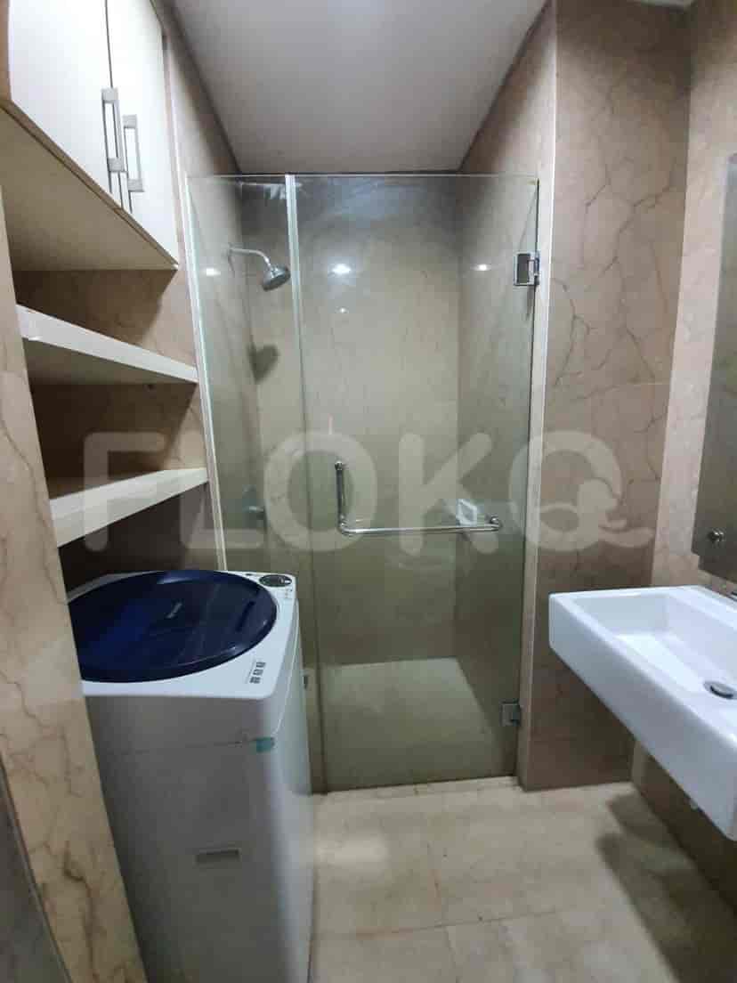 A modern bathroom with a glass-enclosed shower and a washing machine.