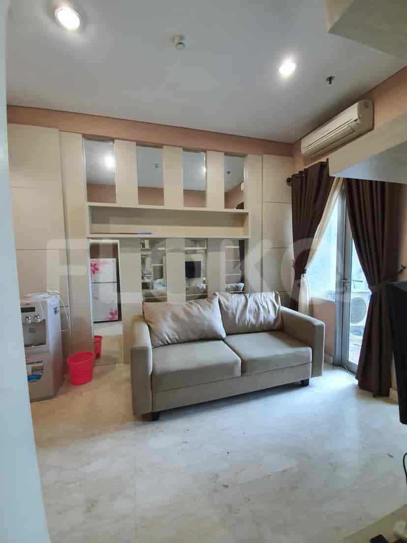 A living area with a sofa, air conditioning, mirrors and a view of a balcony.