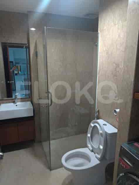 A bathroom with a toilet, shower and a washing machine.