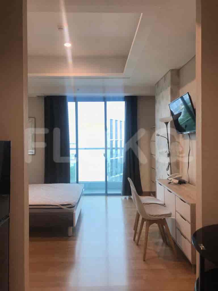 A comfortable bedroom with a large window, a desk, and a modern design.