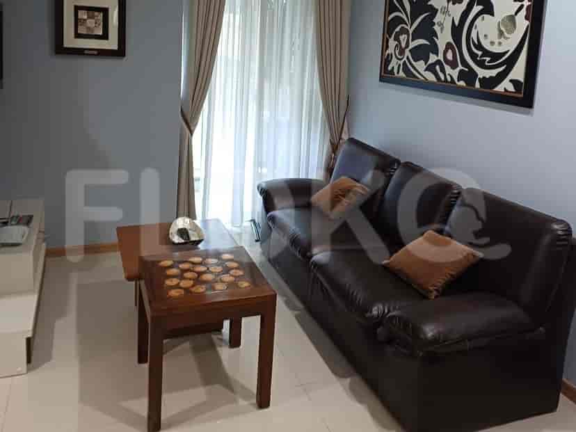 Living room with a brown leather sofa, a coffee table, and a decorative artwork.