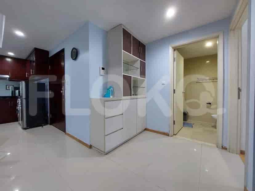 Hallway with storage cabinets, doors to other rooms, and access to the kitchen.