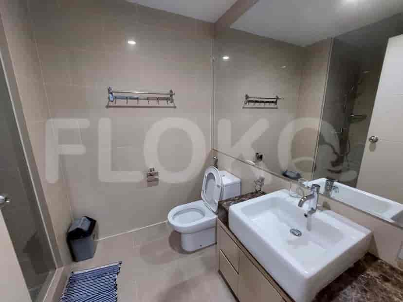 Bathroom with a white toilet, sink, and a large mirror.