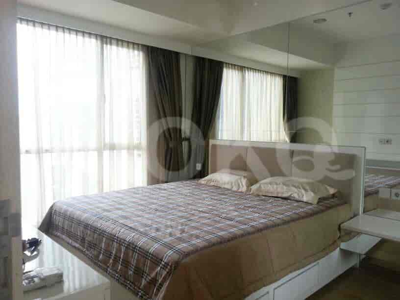 Sebuah kamar tidur yang menampilkan tempat tidur besar, jendela besar dengan gorden, dan dinding cermin.