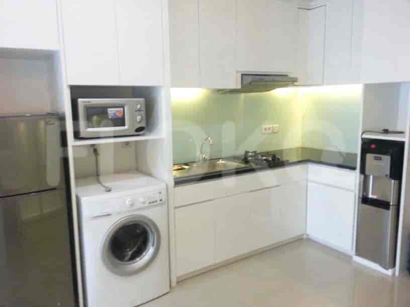 Sebuah dapur yang menampilkan peralatan stainless steel dan lemari putih.