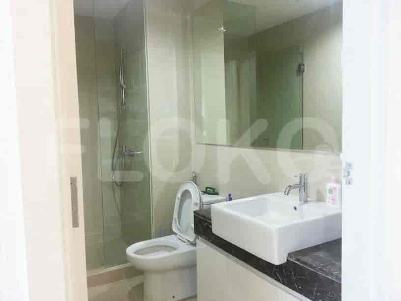 Kamar mandi modern dengan shower berkaca, toilet, dan wastafel.