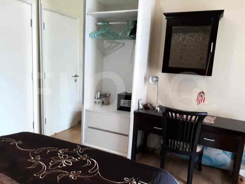 A bedroom with a bed, a wardrobe, and a desk.