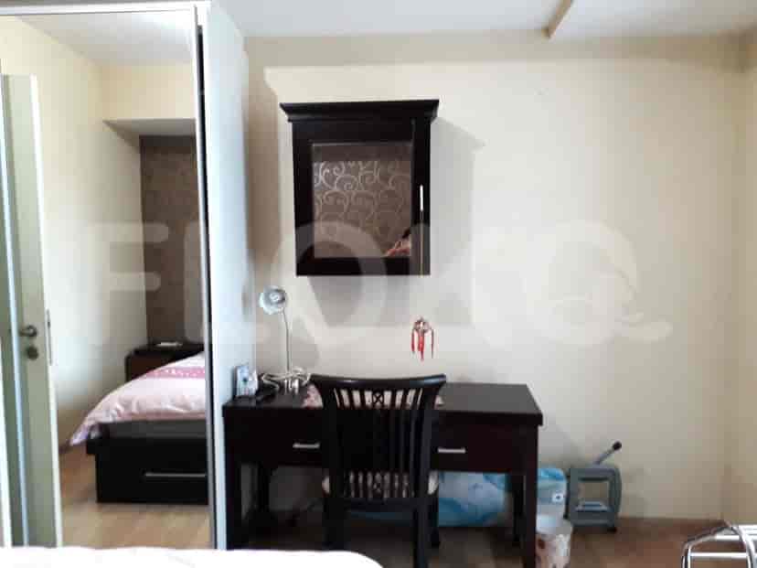 A bedroom with a desk, a chair, and a wardrobe.