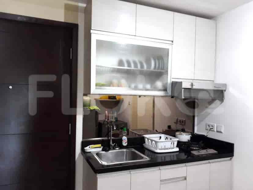 A kitchen with a sink, a stove, and cabinets.