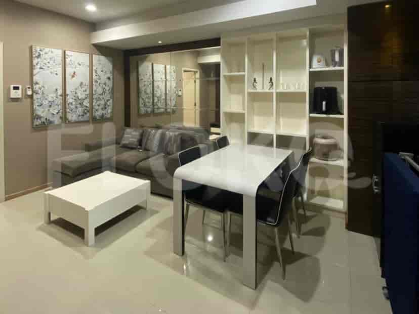 Ruang tamu yang menampilkan sofa abu-abu, meja makan, dan seni dinding dekoratif.