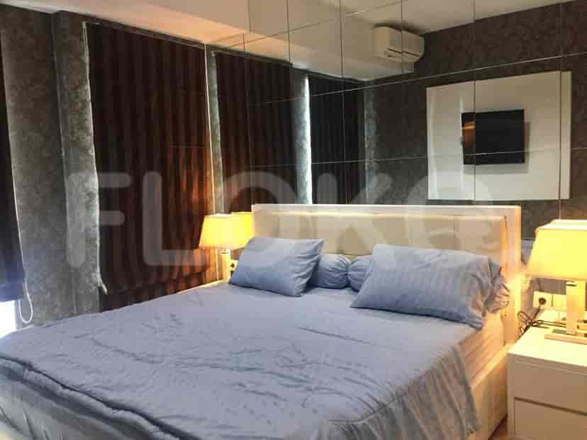 A bedroom with a large bed, side tables, and a mirror.