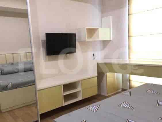 A bedroom with a TV and shelves.