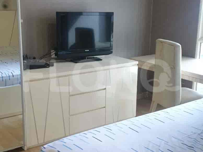 Bedroom with a TV cabinet, TV, and chair.