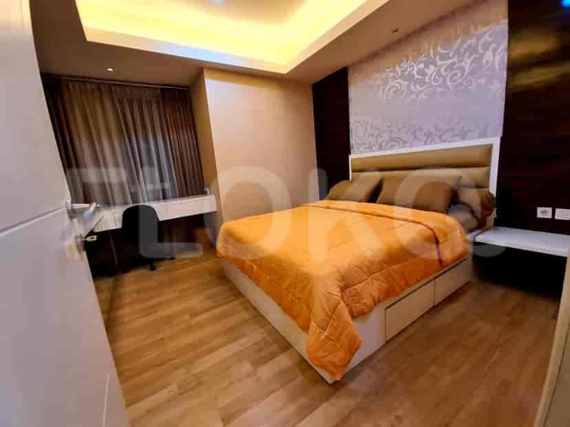 Bedroom featuring a bed with orange bedding, desk, and neutral wall colors.