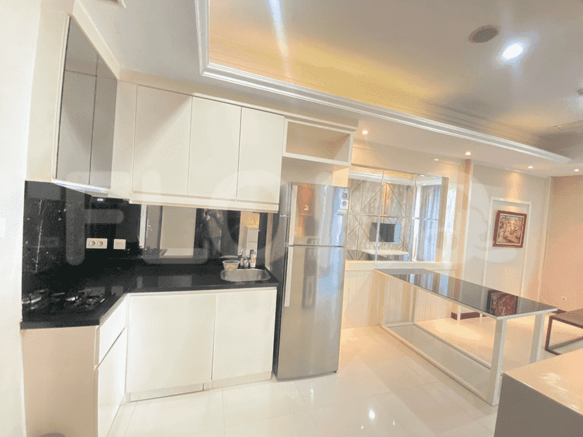 A modern kitchen with white cabinets, black countertop, and stainless steel appliances.