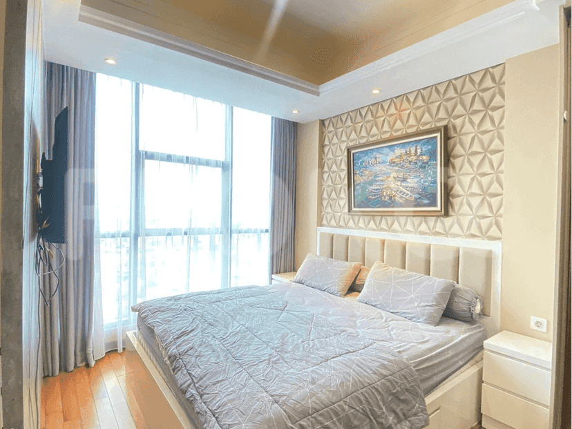 Bedroom with a king-size bed, large windows, and a wall-mounted TV.