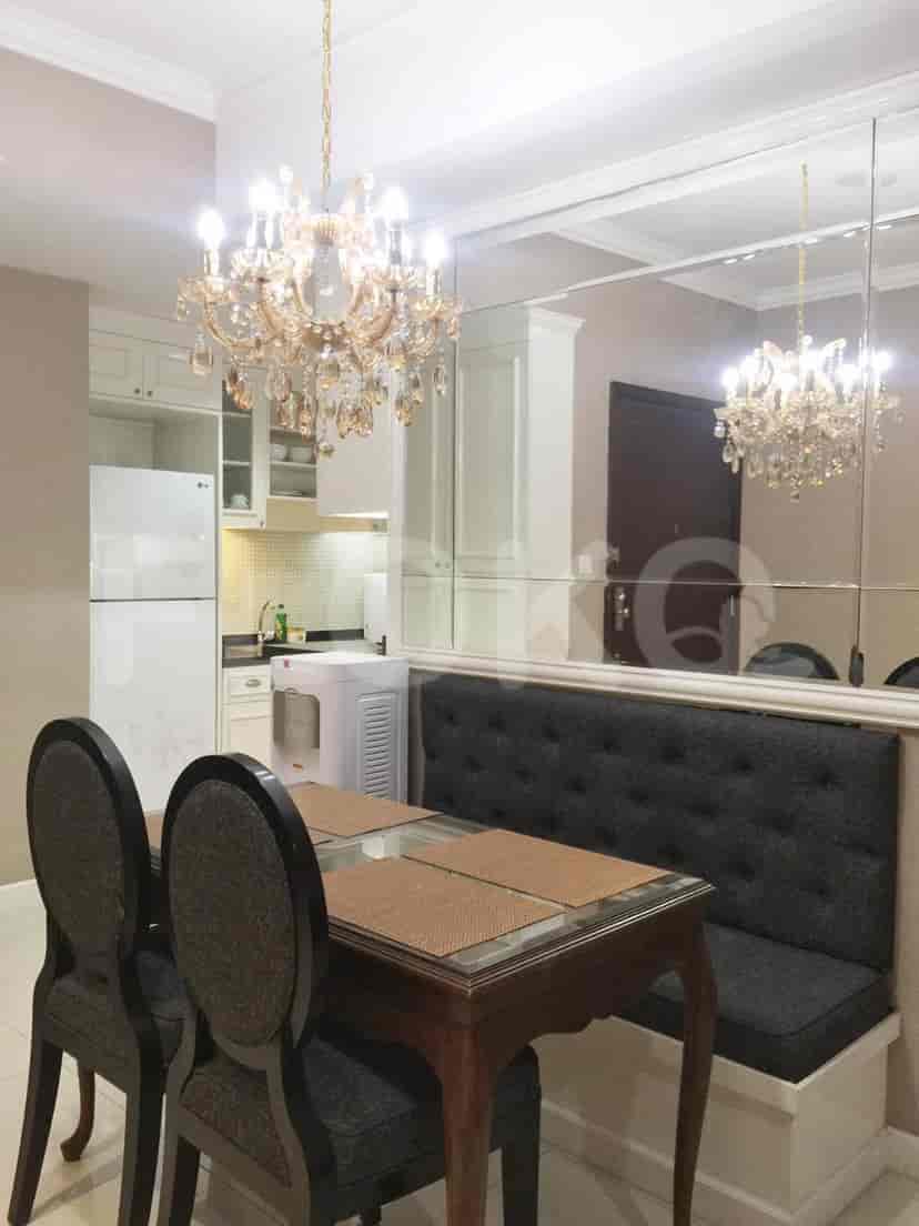 A dining area with a table, chairs, and a large mirror.