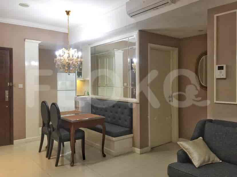 A combined living and dining area with a chandelier, sofa, and a large mirror.