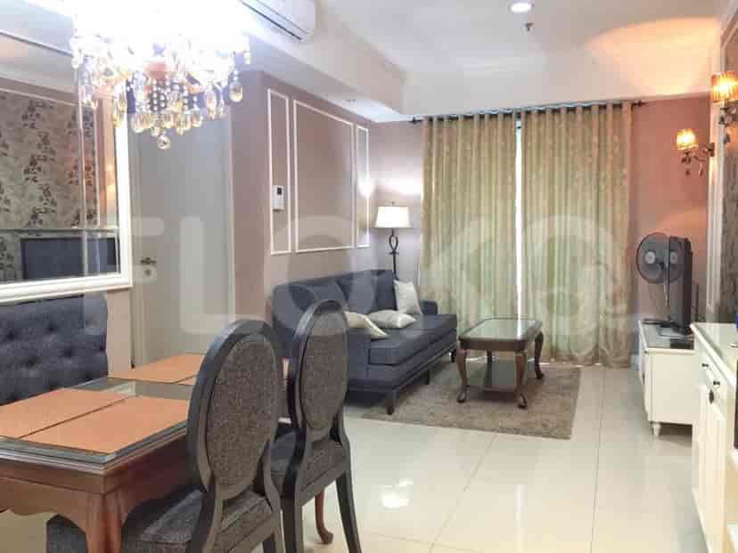 A combined living and dining area with a sofa, dining table, and chandelier.
