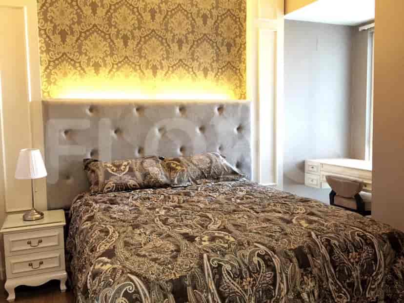 A bedroom with a bed, nightstand, and wallpaper.