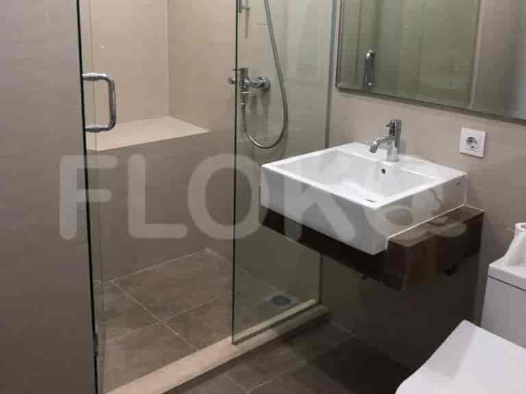 A modern bathroom with a walk-in shower, sink, and a toilet.