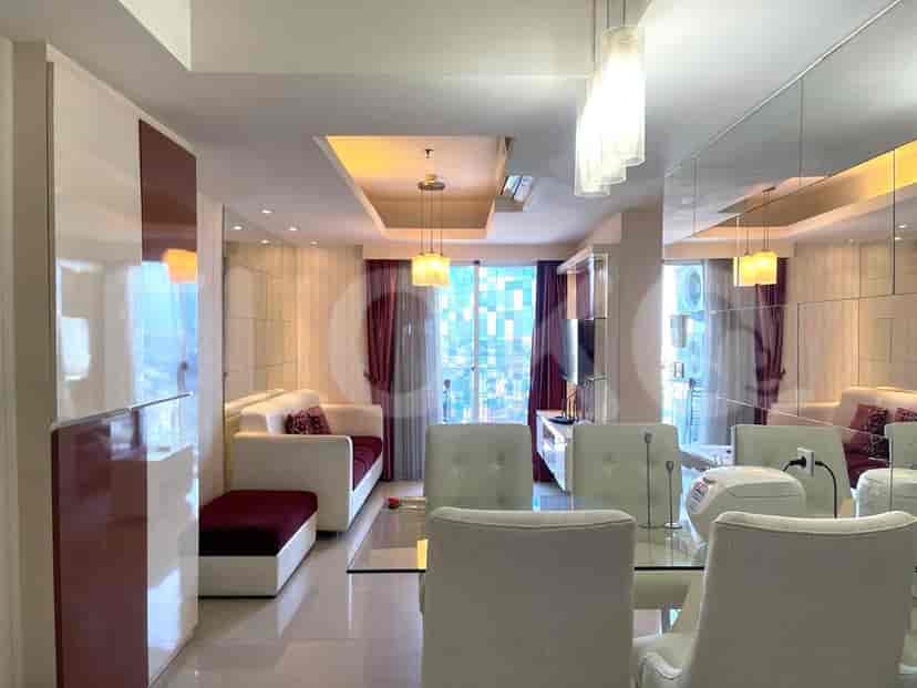 Living room with open layout, dining area, and mirrored wall.