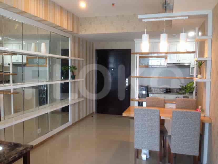 Bright living and dining space with a mirrored wall, open shelves, and a dining table with chairs.