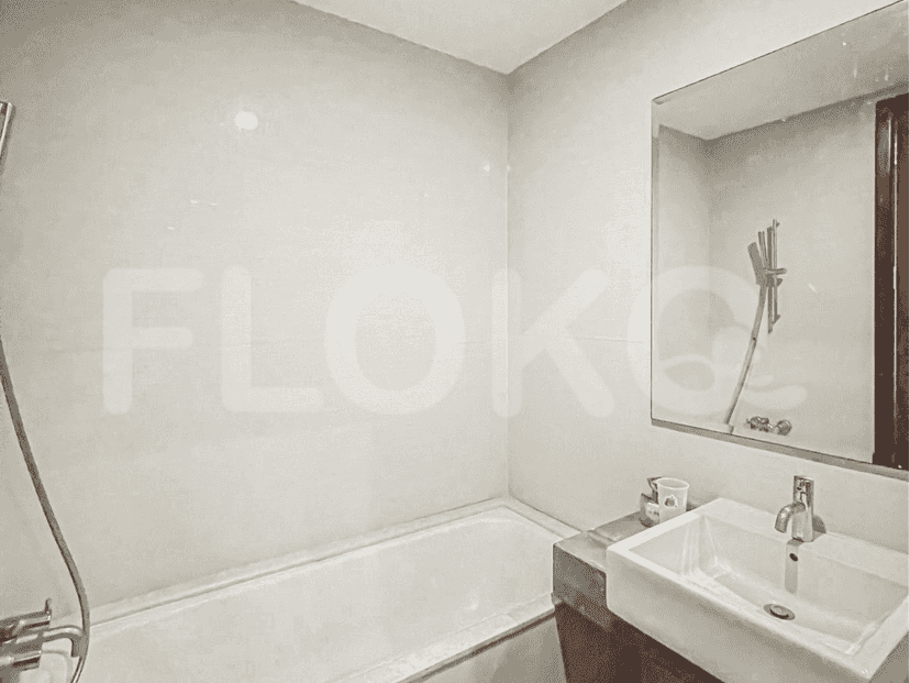 A modern bathroom with a bathtub, a vanity, and bright lighting.