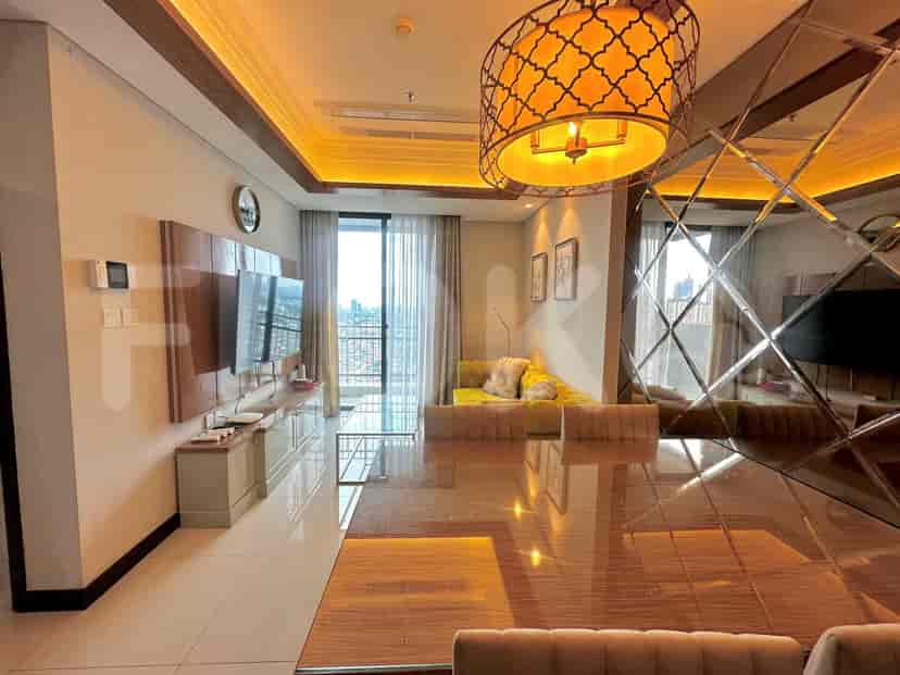 A combined living and dining area with a yellow sofa, dining table, and TV.