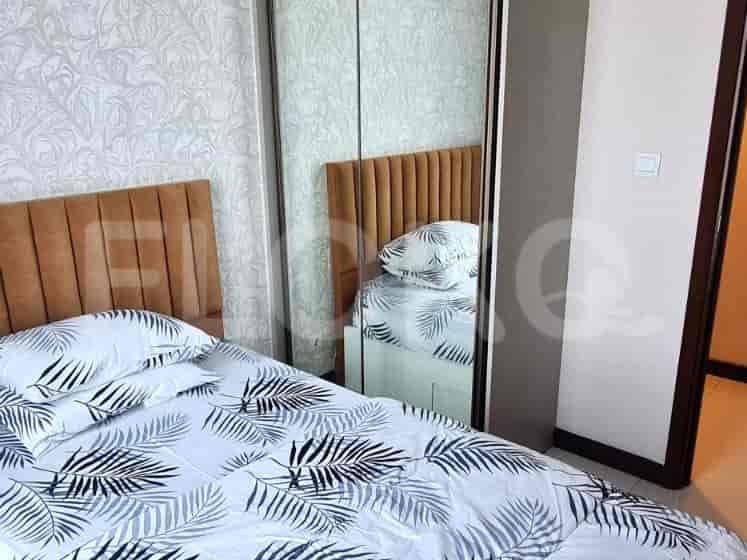 Bedroom with a bed, mirror closet, and wood door.