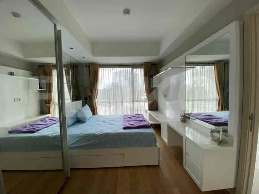 A master bedroom with a bed, built-in wardrobe, and access to a balcony.