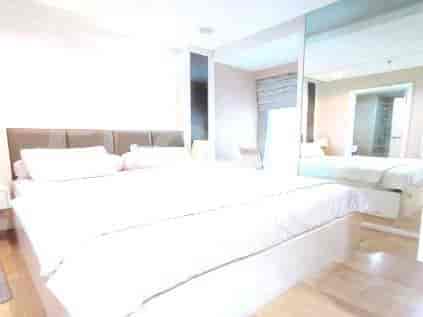 Bedroom with large bed and mirror.