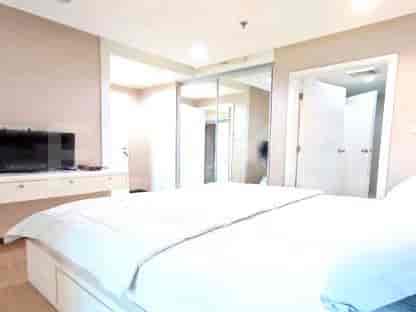Bedroom with a bed, TV and sliding door.