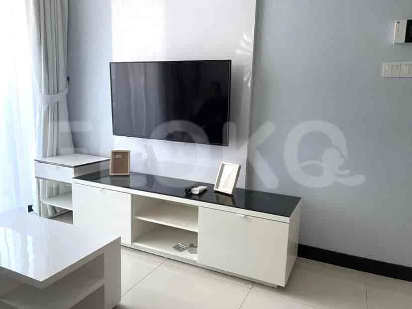 Living room with TV, storage unit and window.