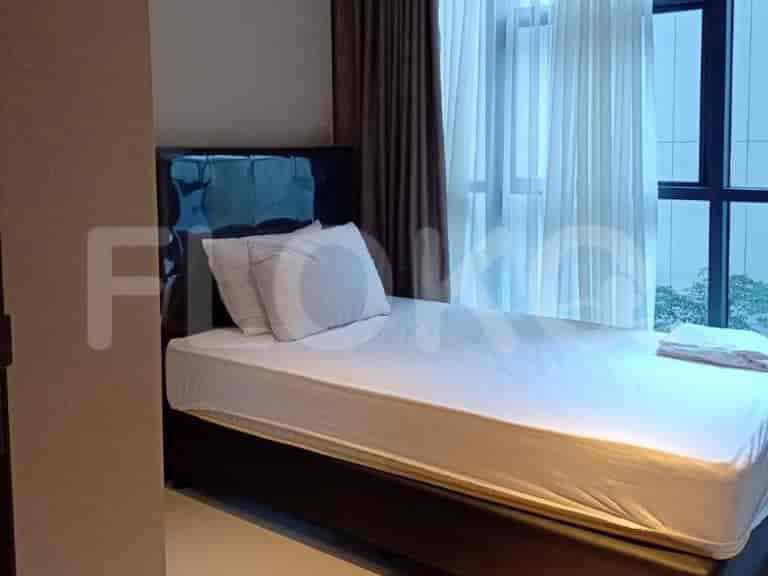 A bedroom with a single bed, pillows, and a window.
