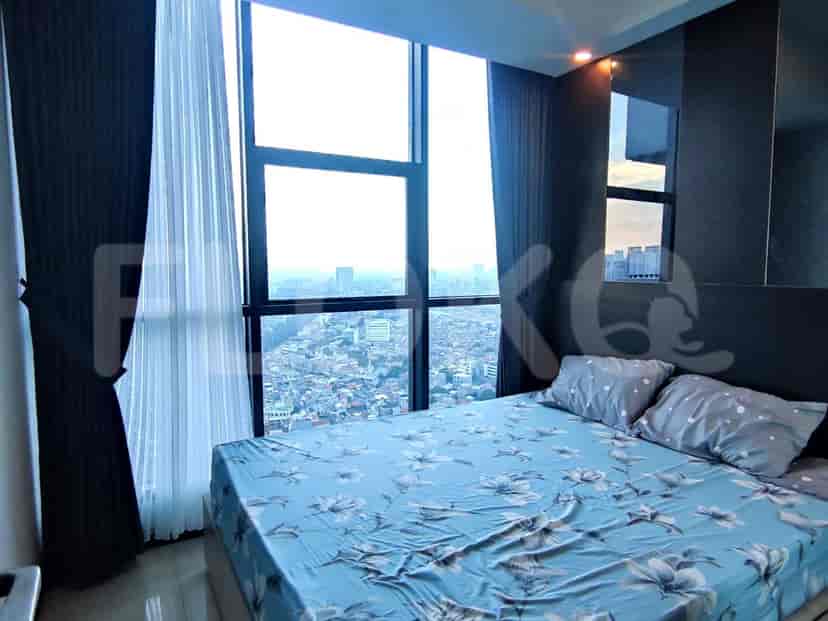 A bedroom with city views, large windows, and a double bed with floral bedding.