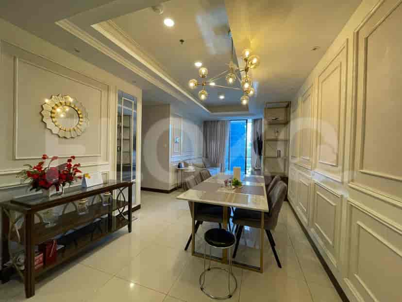 A dining area with a table and chairs, next to an entryway with a mirror and console table.