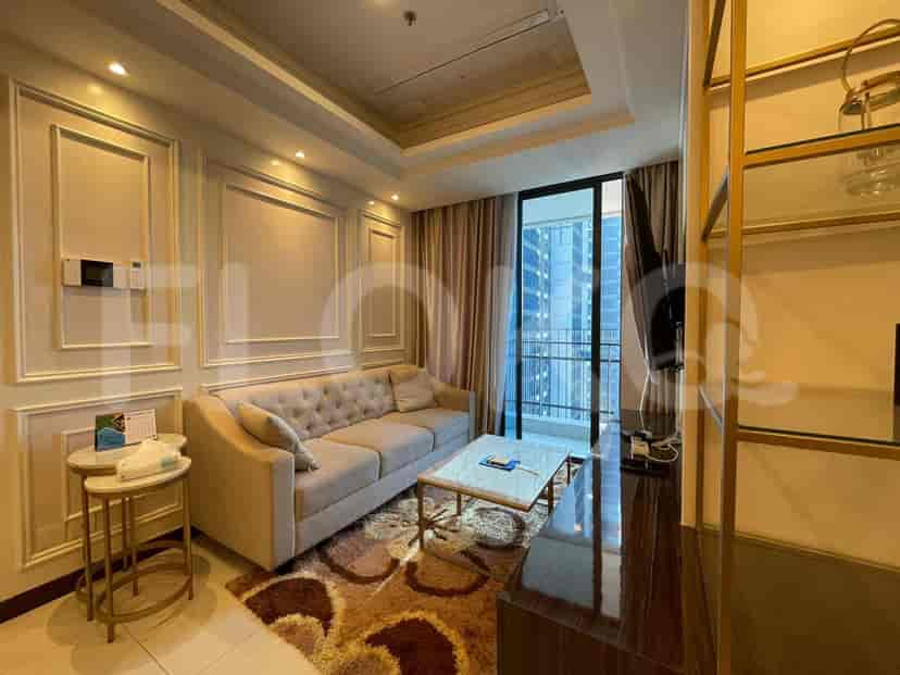 A living room with a sofa, coffee table, and access to a balcony with a city view.