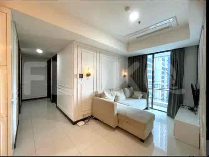 A bright living room with a sectional sofa, a large window, and a hallway leading to other rooms.