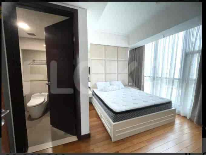 A bedroom with a bed and a bathroom accessible through a door.