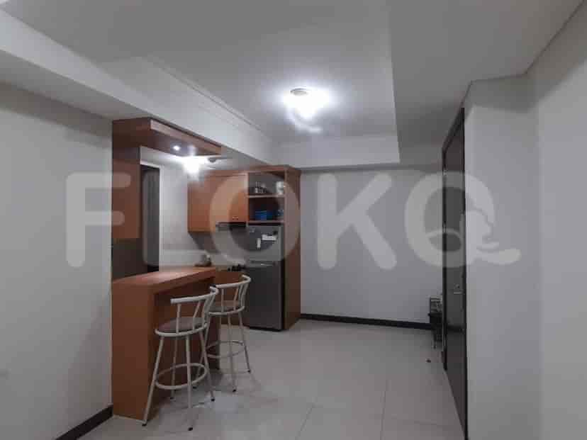 A kitchenette with a breakfast bar, cabinets, and a refrigerator.