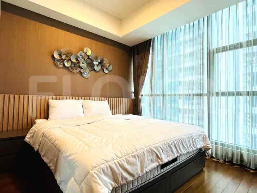 Bedroom with bed, artwork, and large windows.