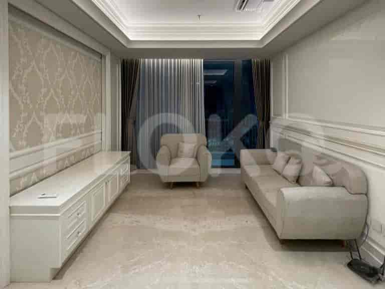 A modern living room with a sofa, armchair, and a large window.