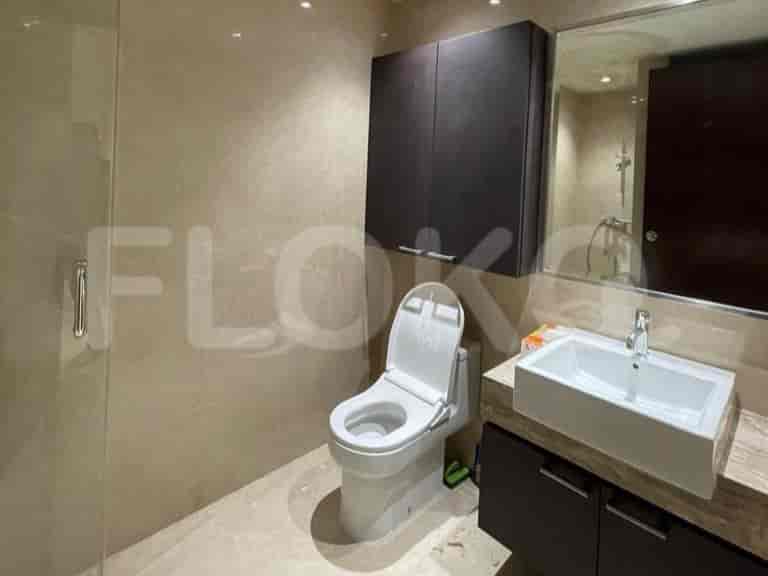 A modern bathroom with a toilet, sink, and mirror.