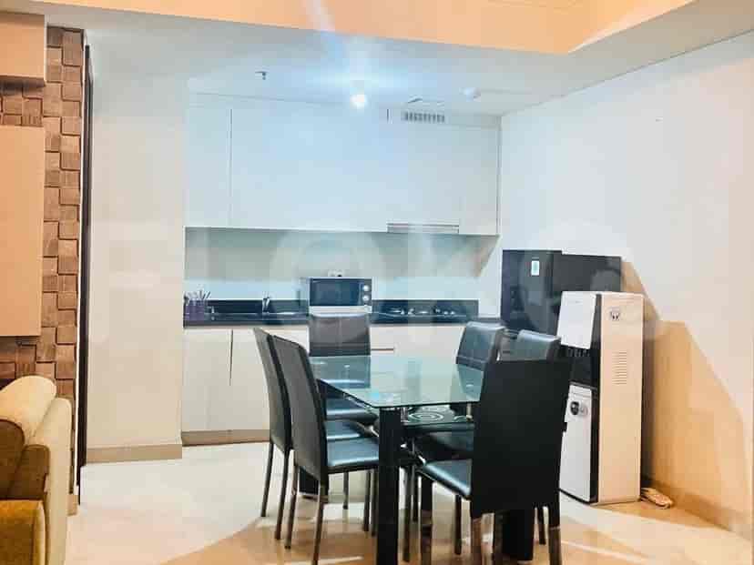 Open kitchen and dining area, with a glass table and black chairs, plus modern appliances.