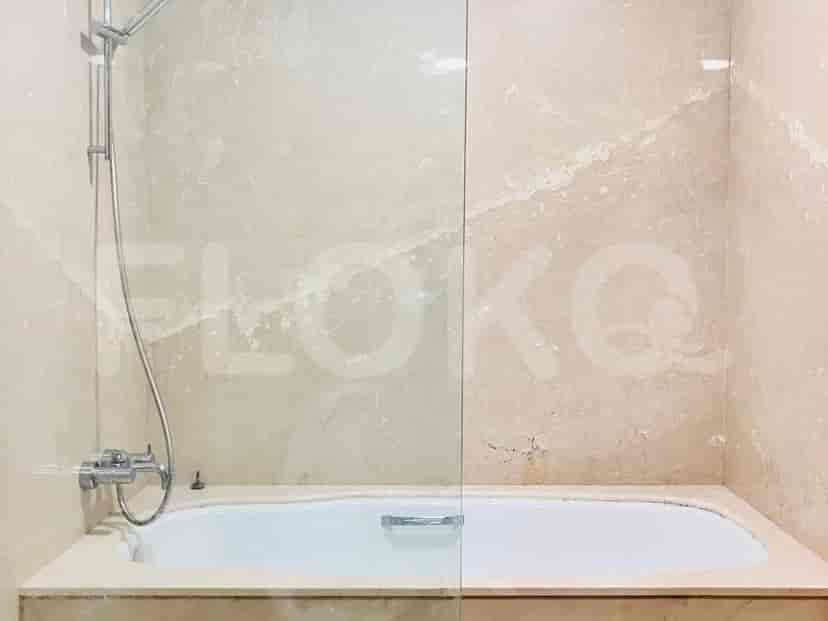 Spacious bathroom with a bathtub, glass shower enclosure, and light-colored marble walls.