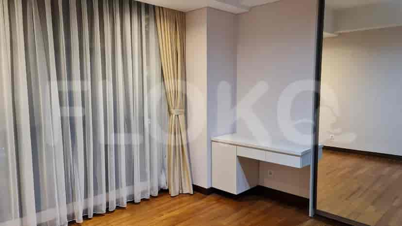 A bedroom with a double bed, vanity table, and large mirror.