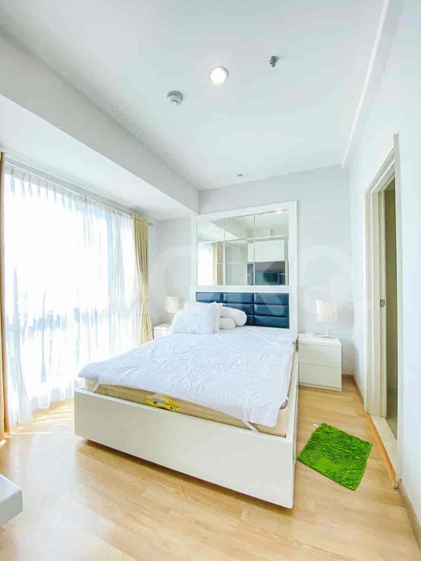 Kamar tidur dengan tempat tidur putih, jendela besar, dan gorden putih.