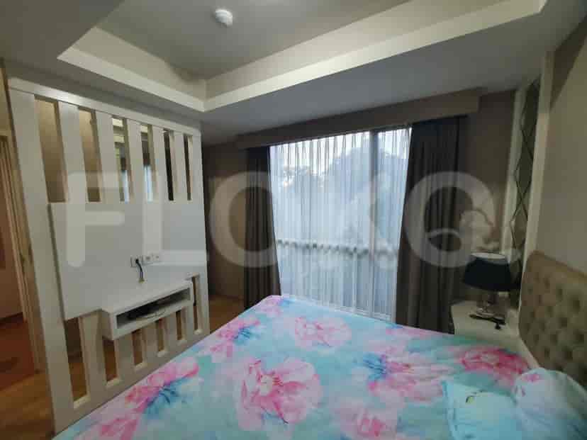 Kamar tidur dengan tempat tidur, partisi dekoratif, dan jendela.